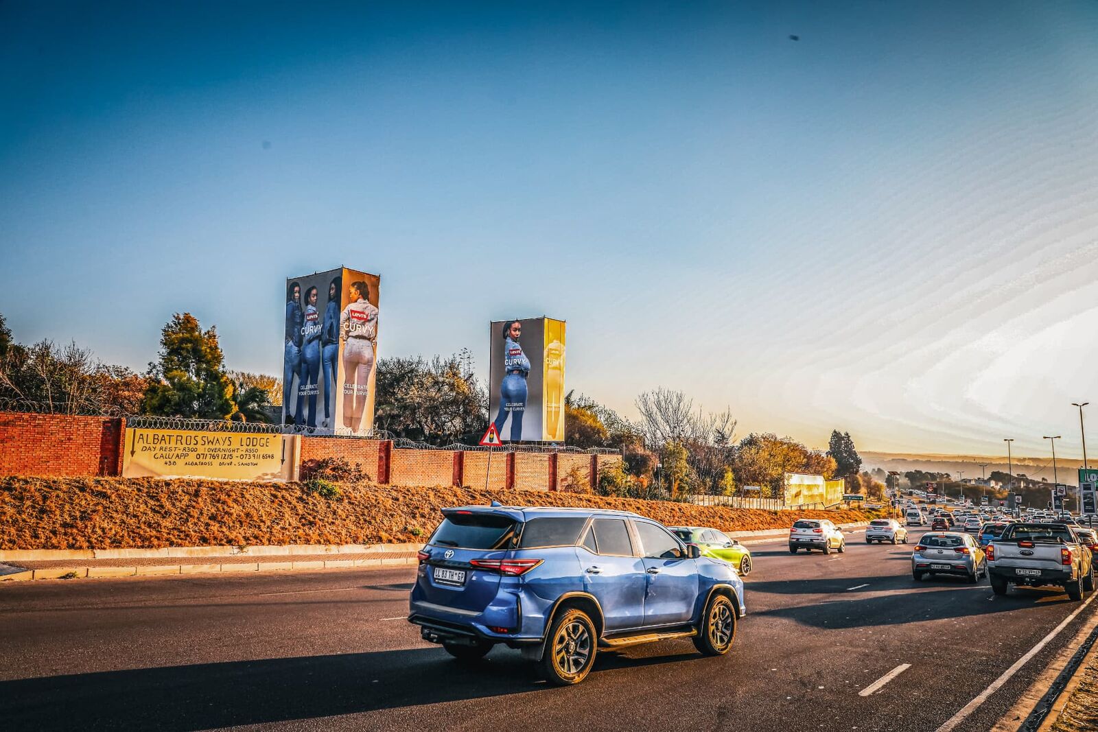 Levi's Curvy printed tower banners installed above a roadside wall